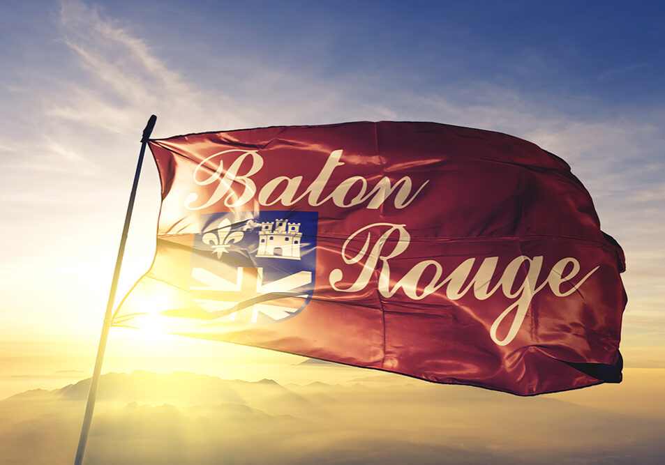 Baton Rouge city capital of Louisiana flag textile cloth fabric waving on the top sunrise mist fog